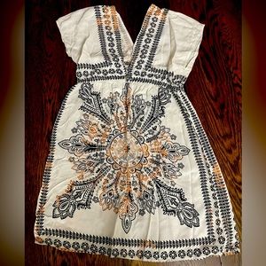 V- neck short sleeve blouse with metal Celtic knot bling in front.